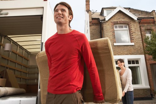 Moving crew navigating a narrow Hackney staircase with a piano