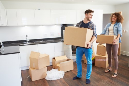 Removal workers navigating stairs during a Hackney home move